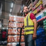 mature man pulling a hand truck at the supermarket