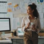 shot of an attractive young businesswoman standing and looking contemplative while holding a cup of coffee in her home office