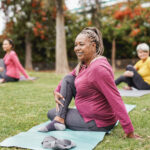 multiracial women doing yoga exercise with social distance for coronavirus outbreak at park outdoor healthy lifestyle and sport concept