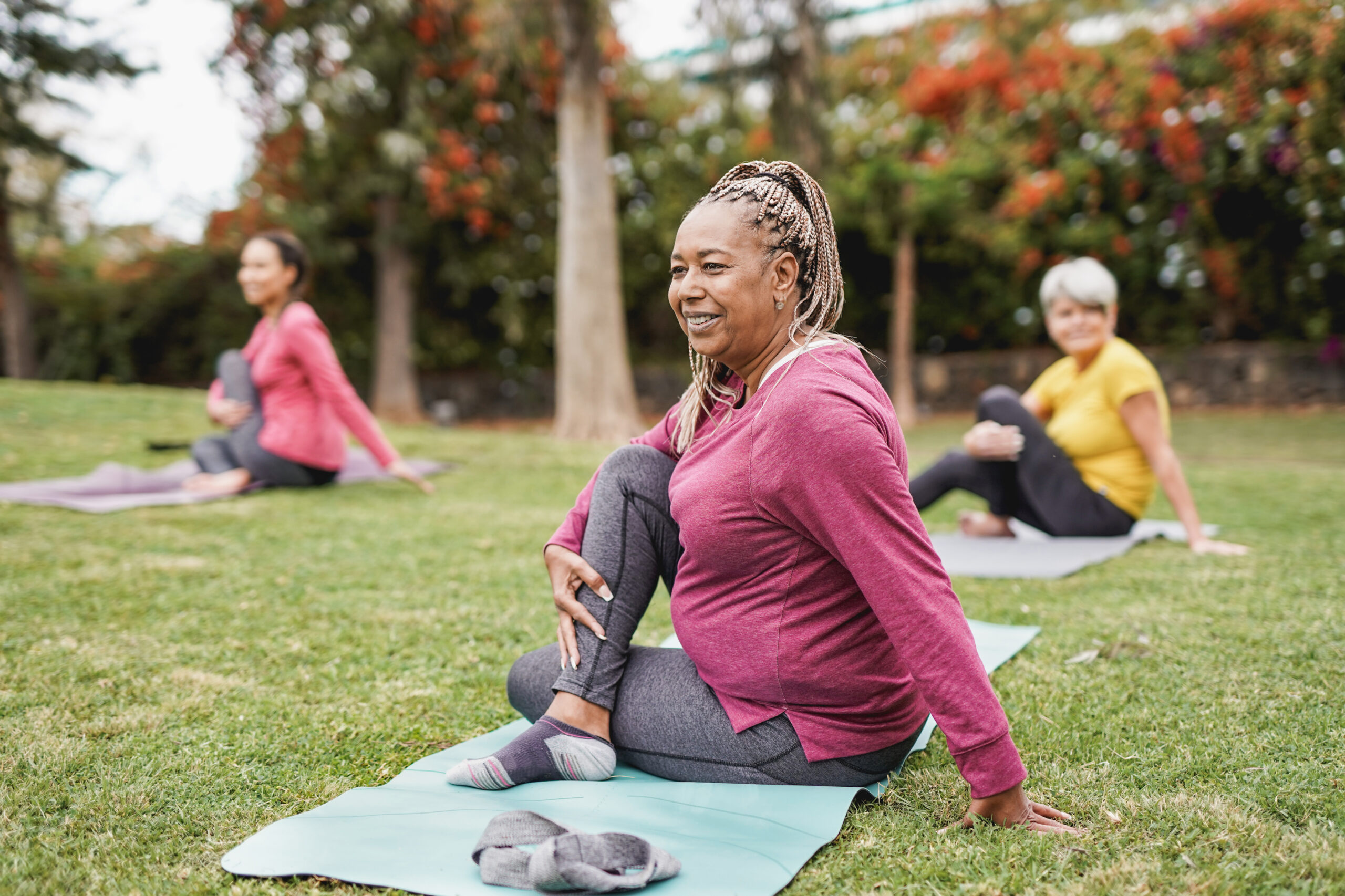 multiracial women doing yoga exercise with social distance for coronavirus outbreak at park outdoor healthy lifestyle and sport concept