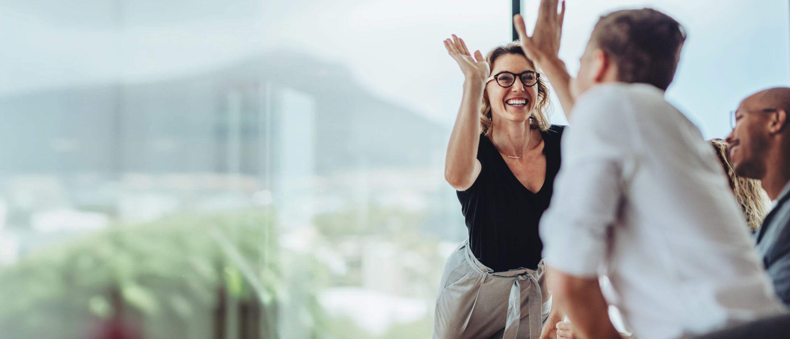 businesswoman giving a high five to a colleague in meeting